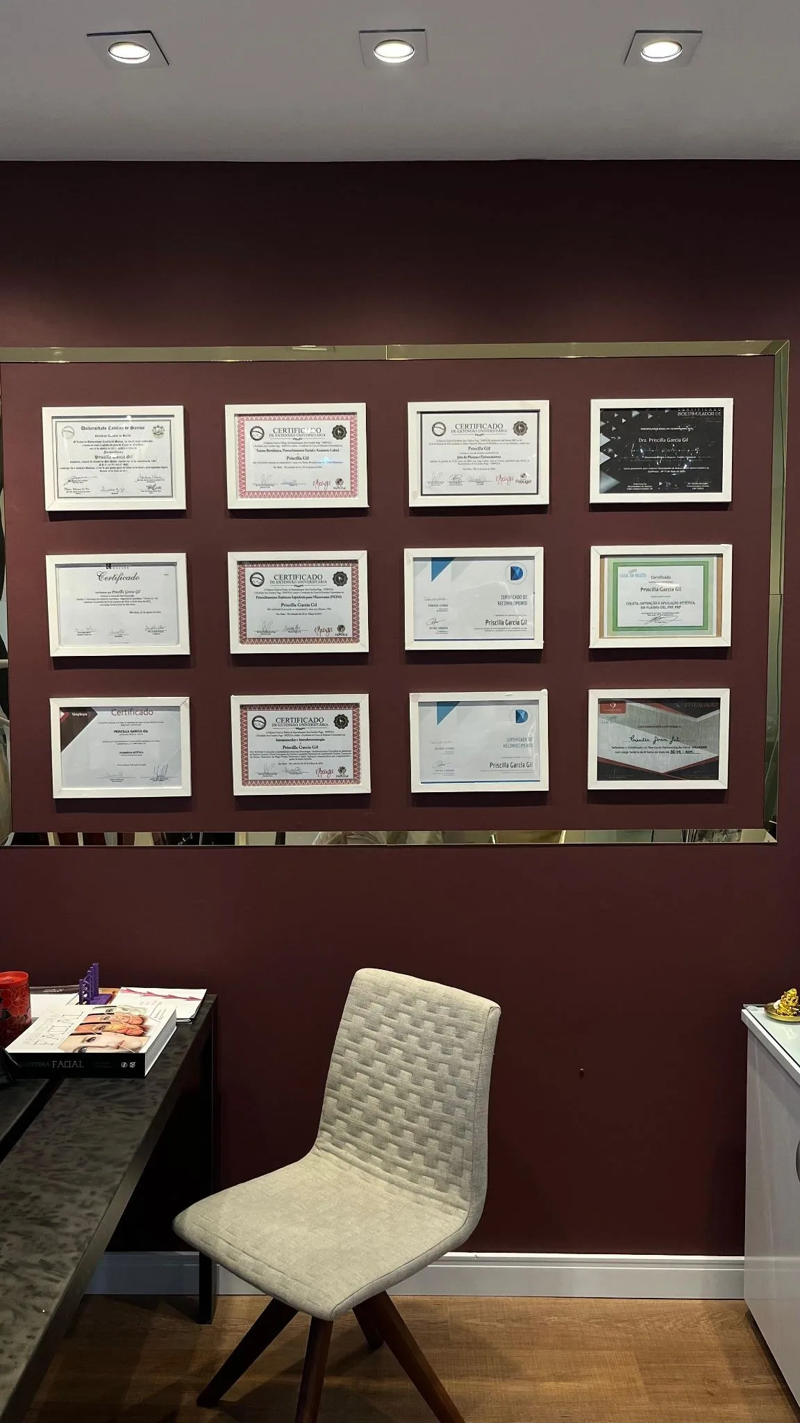 Parede de certificados e formações da Dra. Priscilla Gil